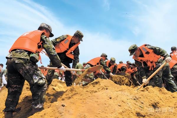 武警湖南总队官兵装填搬运沙袋加固华容县团洲垸堤坝